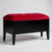 Elegant black piano bench with a plush, rounded red velvet tufted seat and tapered legs.