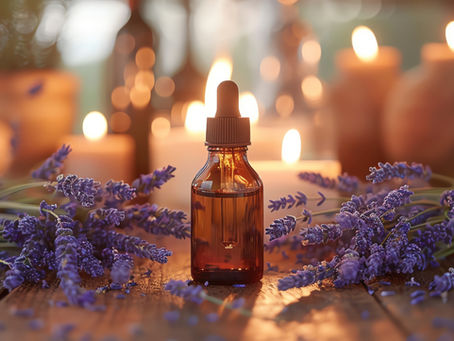 Braunglasflasche mit Lavendelöl, umgeben von frischen Lavendelblüten und brennenden Kerzen – Symbol für Rituale mit Lavendel für den Alltag.