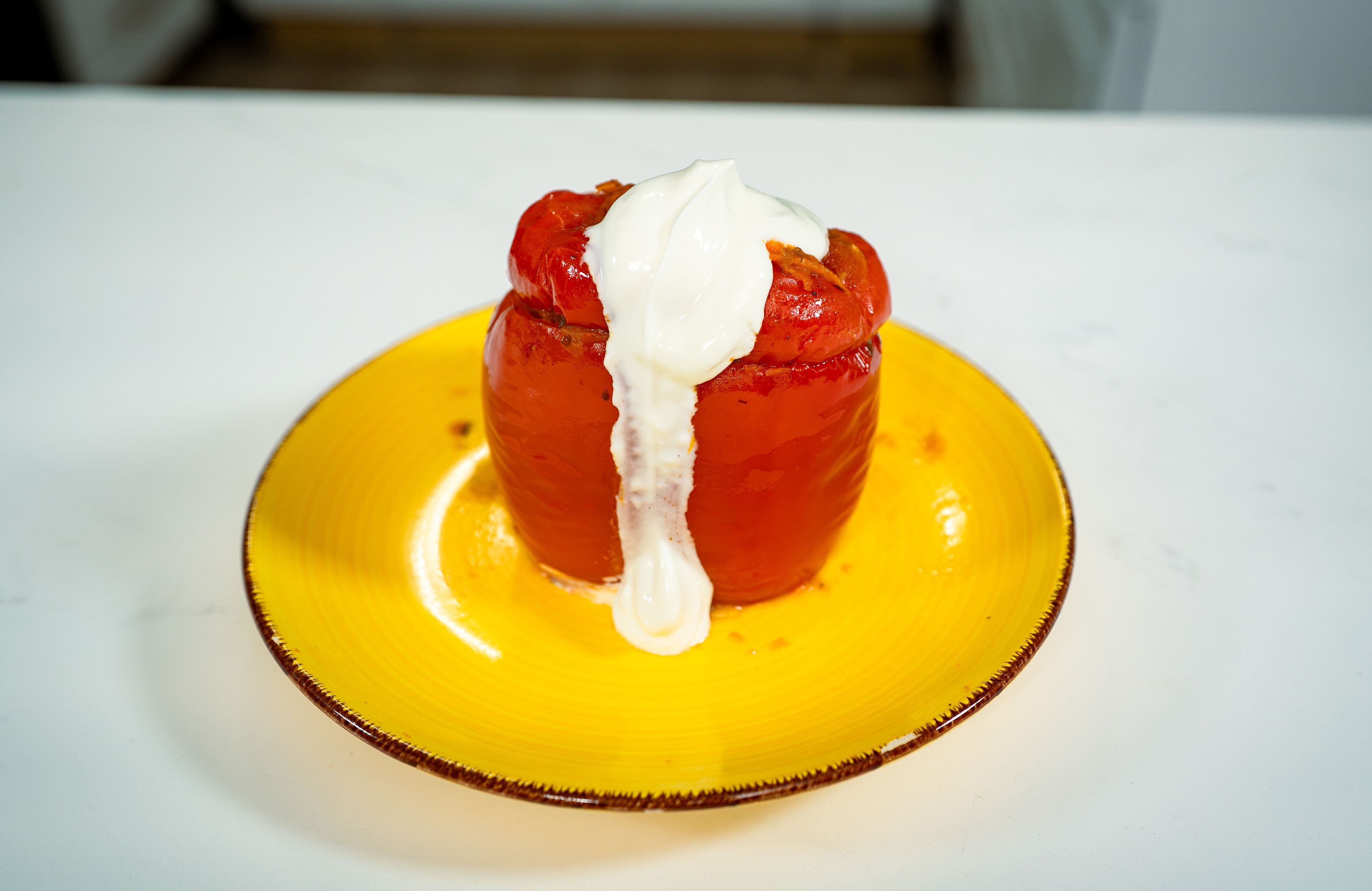 Stuffed peppers with beef, pork and rice, served with sour cream