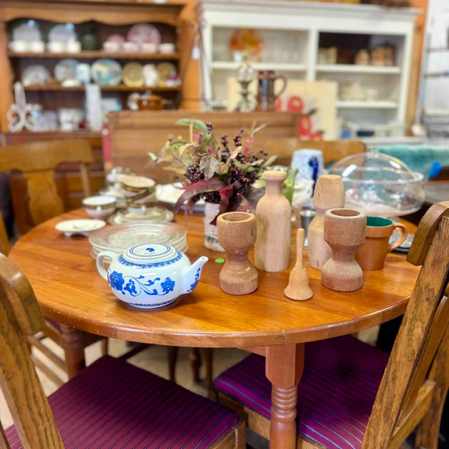 Wooden table displays vintage tea set and home decor