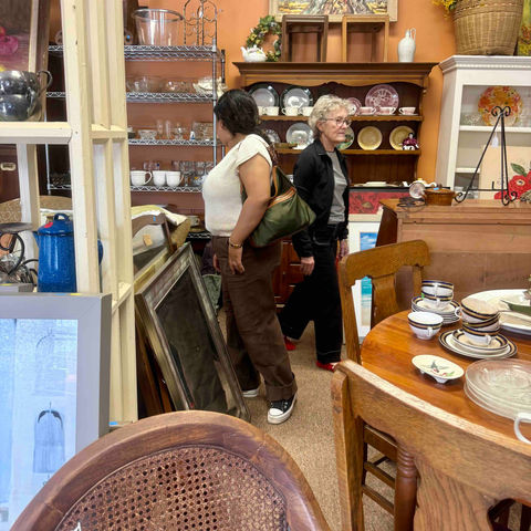 Women browsing antique frames and furniture at Cottage Treasures