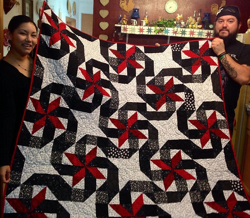 Roman Barham and Kristin Melton displaying Quilt