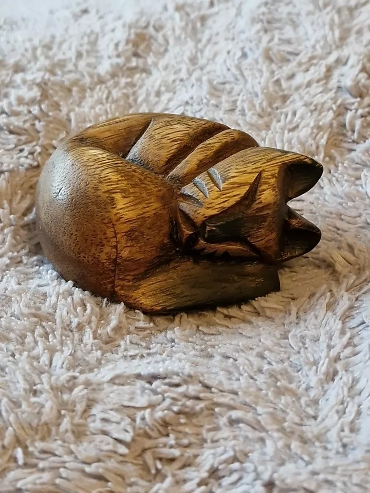 Front view of carved wooden sleeping cat