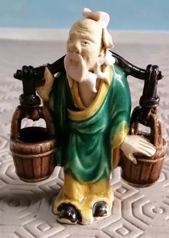Close front view of the Vintage Chinese Mudman Carrying 2 water buckets across his shoulders