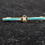 Thumbnail: Front view of the Small Green Bar Style Brooch in Yellow Metal with Clear and Coloured Stones
