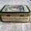 Thumbnail: Left side view of the Southern Comfort Tin With a Steamboat Design on the lid