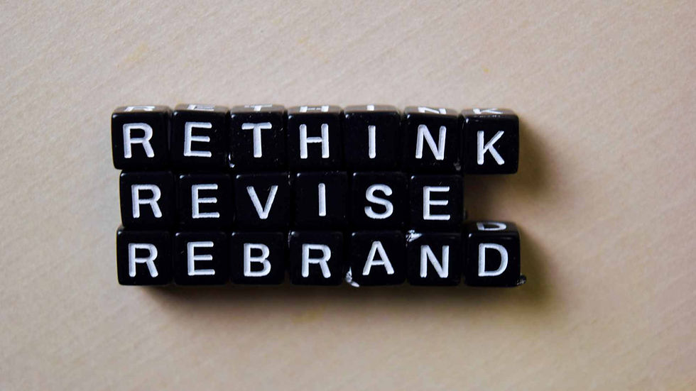 Cubos pretos formando as palavras rethink, revise e rebrand, representando o conceito de rebranding e transformação de marca