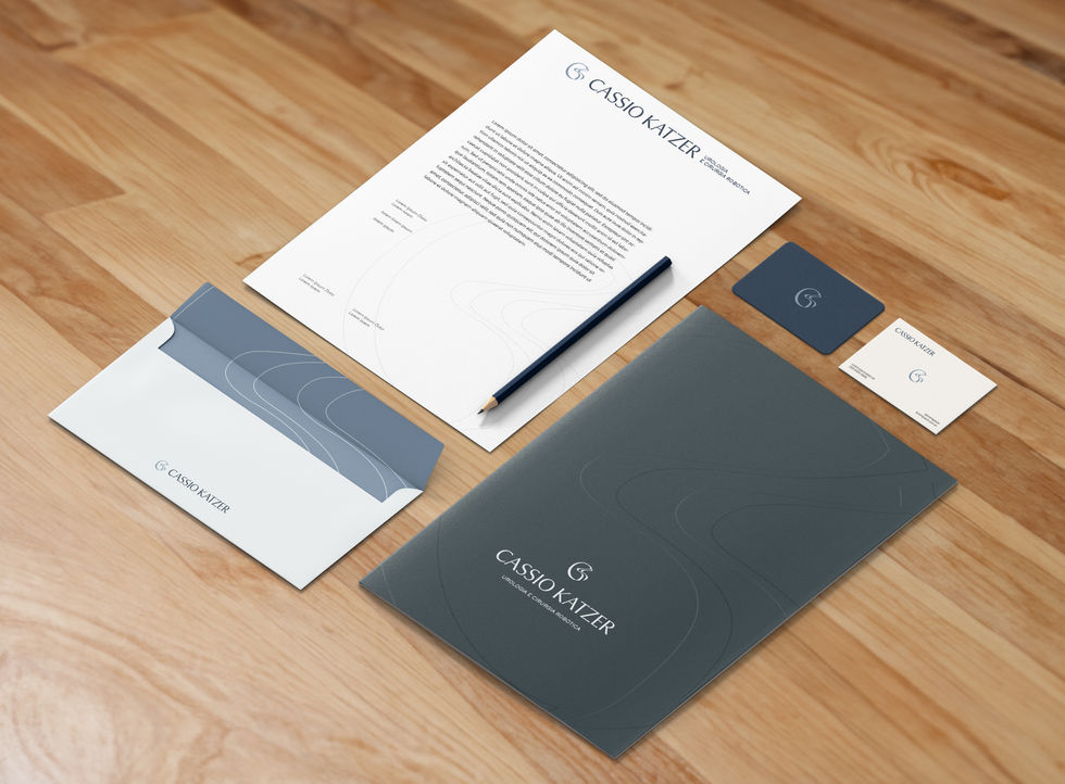 Kit de papelaria médica personalizada da marca Dr. Cassio Katzer espalhado sobre uma superfície de madeira clara.