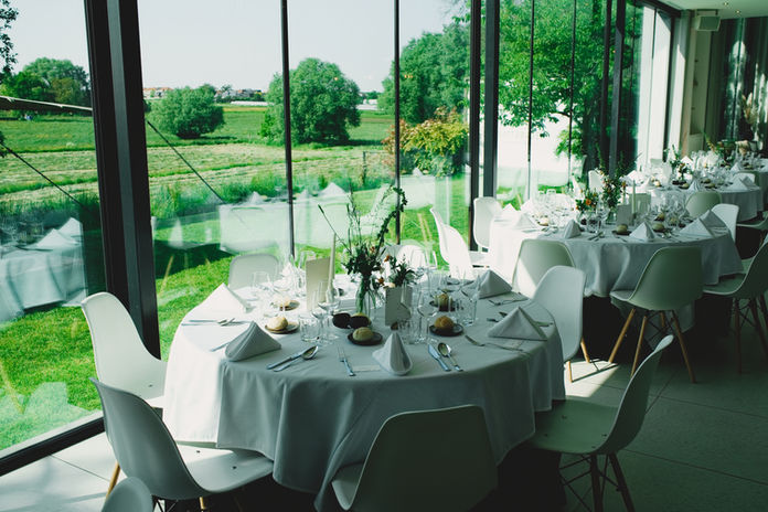 Tafelaankleding met verschillende vaasjes op ronde tafels.
