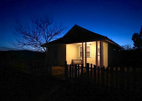 Porch-lit bunkhouse against evening sky