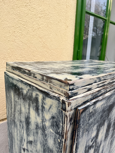 Die Oberseite einer dunklen Kommode im Shabby Chic Stil