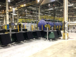 Industrial workplace with yellow safety railings and large machinery
