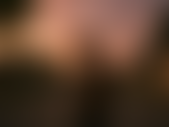 A man stands on a quiet suburban street at sunset, with orange skies and houses lining the road. The mood is reflective and calm.