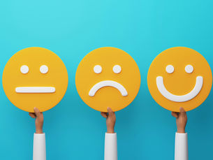 Three hands hold yellow face icons showing neutral, sad, and happy expressions on a turquoise background.