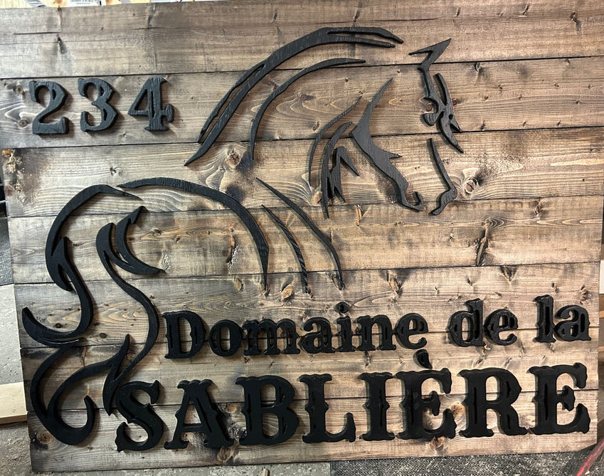 Enseigne sur mesure pour le Domaine de la Sablière, avec un logo créé en collaboration pour représenter son domaine équestre. Fabriquée en bois recyclé, cette pièce artisanale est authentique et élégante.