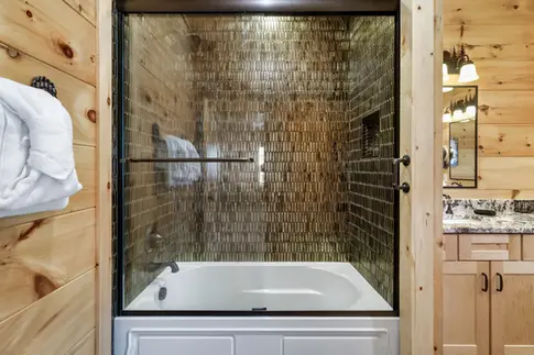 bathroom knotty pine walls woodplank porcelain tile floor kohler bath tub ferguson bronze framed shower surround fine shimmering glass tile with niche maple cabinets