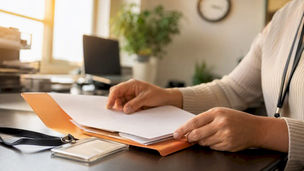 Hands organizing credentialing documents in office