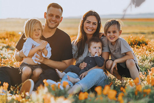 3 women and 2 men sitting on green grass