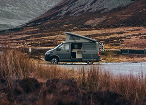 campervan parked in front of a mountain
