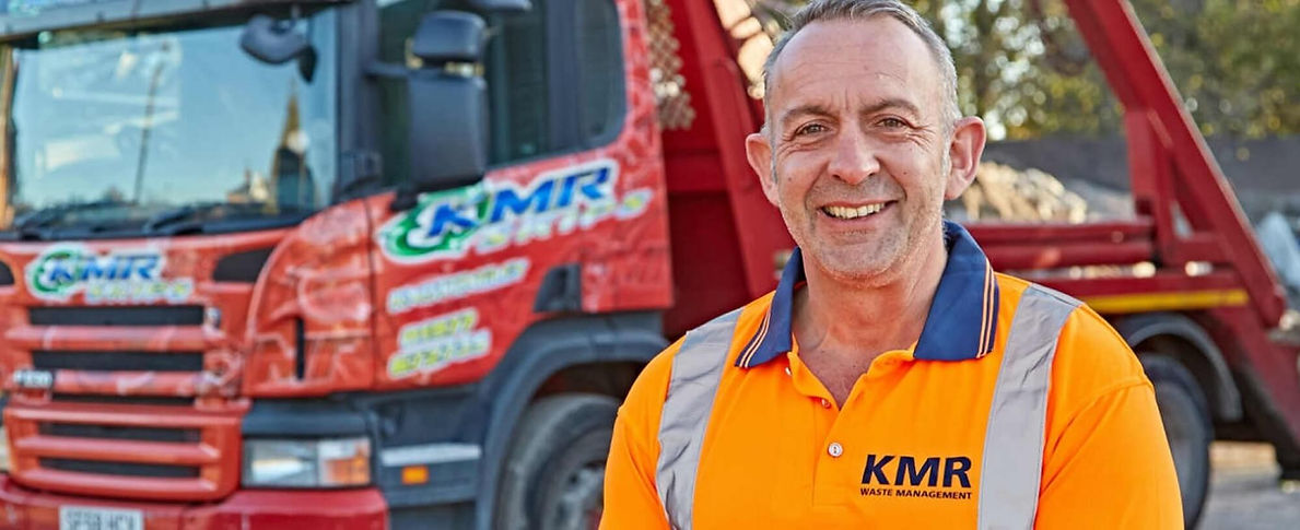 KMR Skip Hire employee in front of branded truck