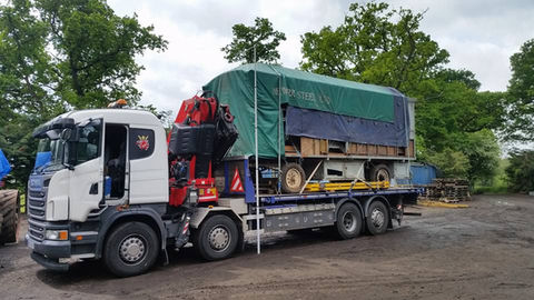 Fully loaded truck with covered plant machinery ready for transportation 