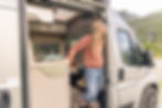 woman looking out of campervan door