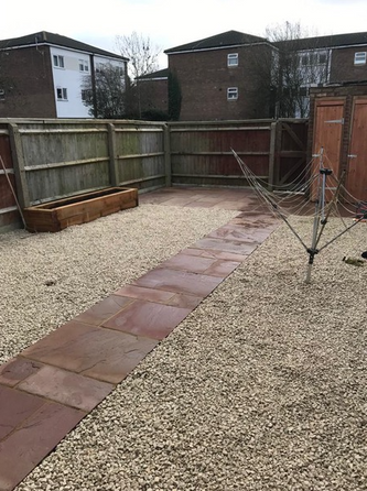 gravelled back garden with fence and washing line 