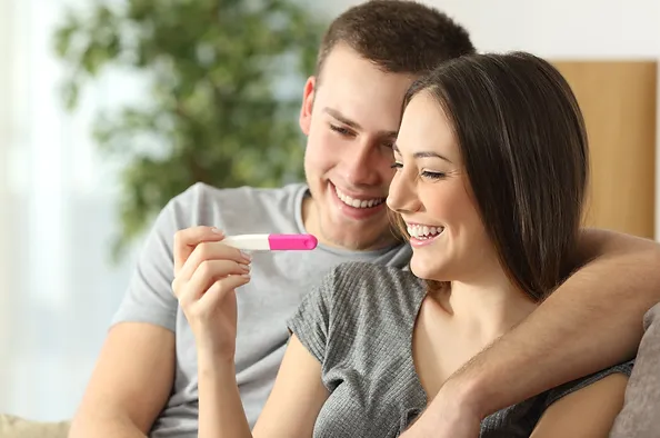 Happy couple checking pregnancy test sit.webp