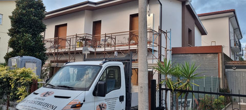 Furgone Impresa Costruzioni davanti a casa con impalcatura.
