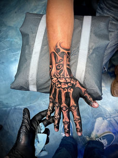 a hand with a skeleton tattoo on it