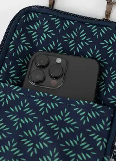 green and blue purse with cell phone sitting in pocket