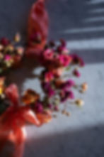 Hand holding a bouquet of blush pink, lilac, and white flowers with long stems against a grassy background. Elegant and serene mood.
