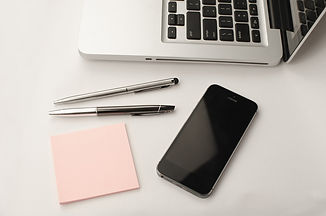 Laptop with pens sticky notes and smartphone