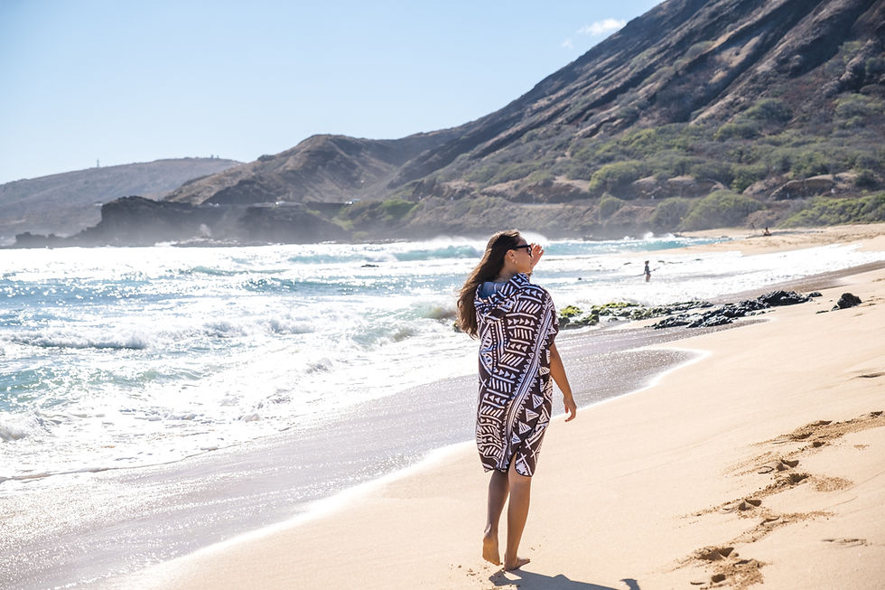 Thumbnail: Adult wearing Black Tribal Pattern beach poncho while walking along the shoreline.