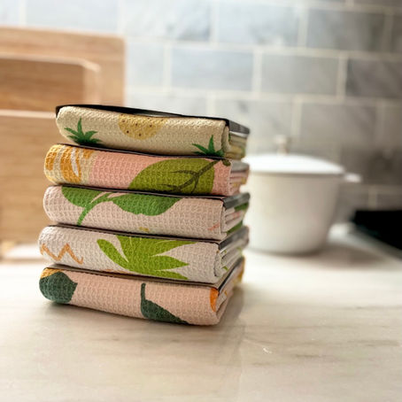 Folded tea towels stacked on a counter for a thoughtful welcome basket gift