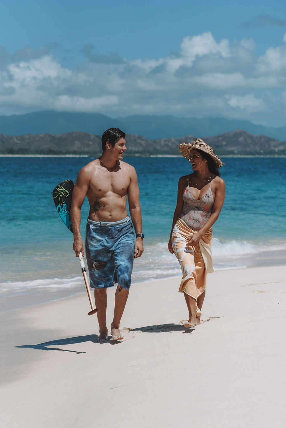 Couple walking on a Hawaii beach with eco-friendly quick-dry microfiber beach towel