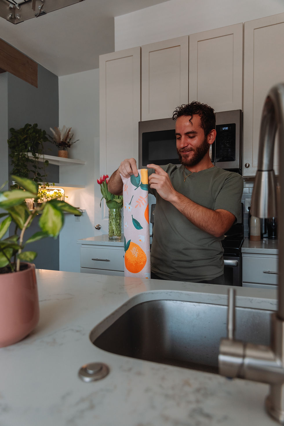 Thumbnail: Lemon & Orange kitchen tea towel held in a kitchen.