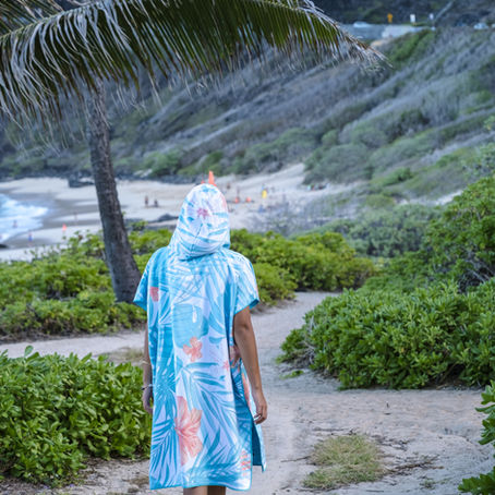 Adult wearing an RHB Hawaii quick-dry beach poncho towel while walking toward the beach, designed for beach days, pool time, travel, and easy changing after swimming.