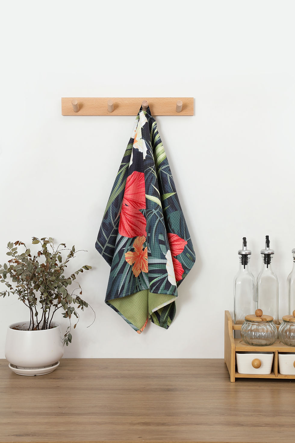 Botanical kitchen towel hanging on a hook in a bright everyday kitchen