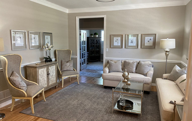 Elegant living room with couches, chairs, pictures, and a coffee table. Ferreras Design
