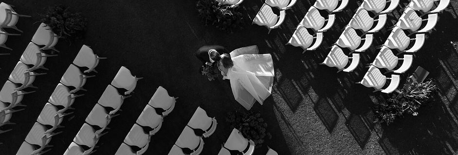 Drone shot of a wedding couple walking through their outdoor dinner setup, captured by Adam Griffin Photo in Los Angeles.