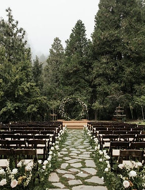 Outdoor ceremony setting at Miller’s Landing in Lake Arrowhead surrounded by pine trees and greenery