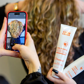 Capturing a picture of curly hair on a phone next to curly hair products.