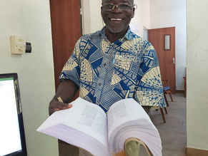 Un homme tient une Bible en borgu fulfulde