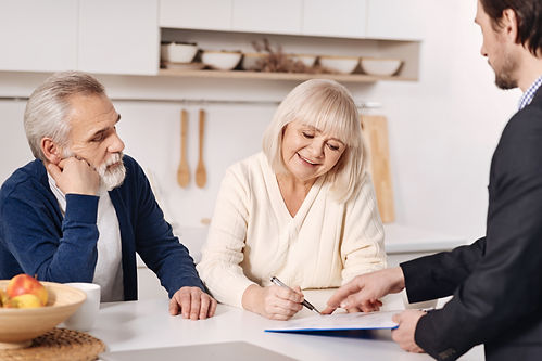 the-moment-of-signing-the-agreement-decisive-positive-senior-couple-sitting-at-home-and-ha