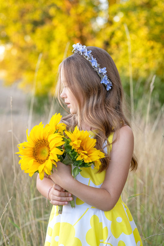 Portrait eines Mädchen mit Sonnenblumen bei warmem Sommerlicht