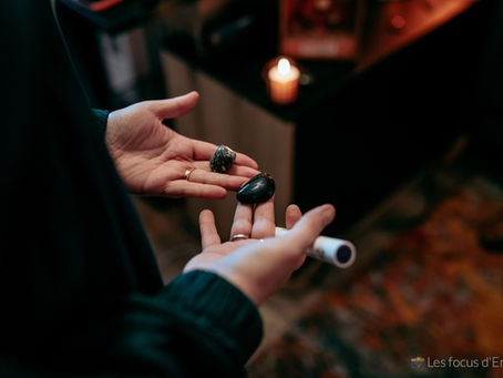 Des mains ouvertes tenant deux pierres noires