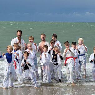 Karateka’s ondergaan natte strandtraining