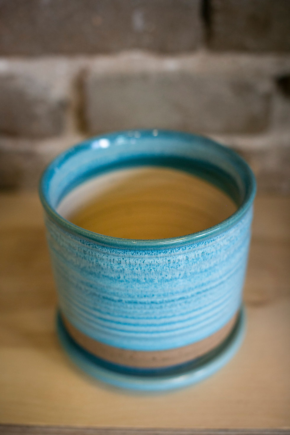 Light blue striped ceramic vase with matching saucer
