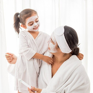 mere-sa-jeune-jolie-fille-s-amusant-dans-chambre-faisant-masques-faciaux-argile_181624-523